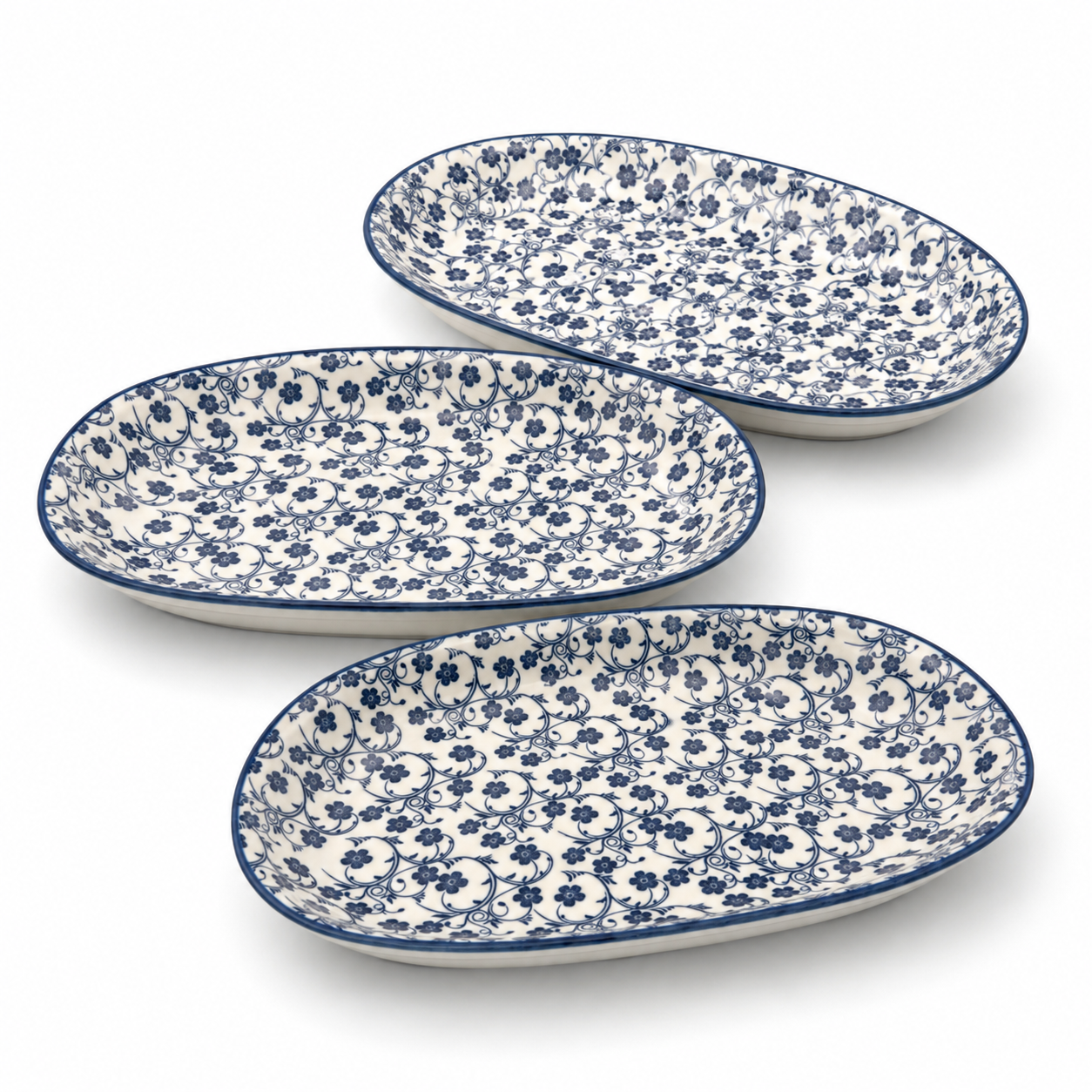 Three oval ceramic plates with blue floral pattern on a white background