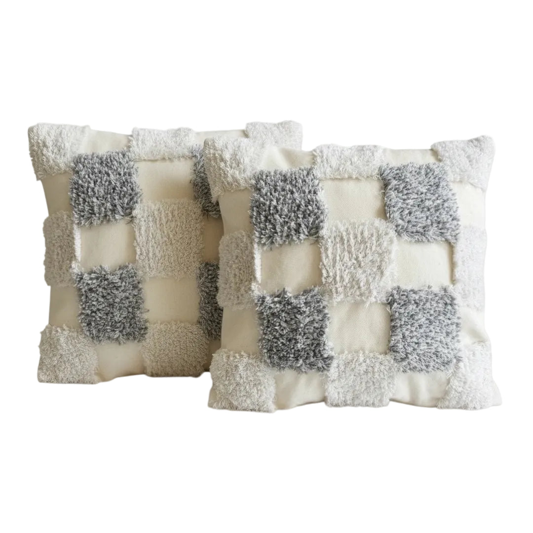Two decorative grey and white pillows covers with a checkered pattern on a white background