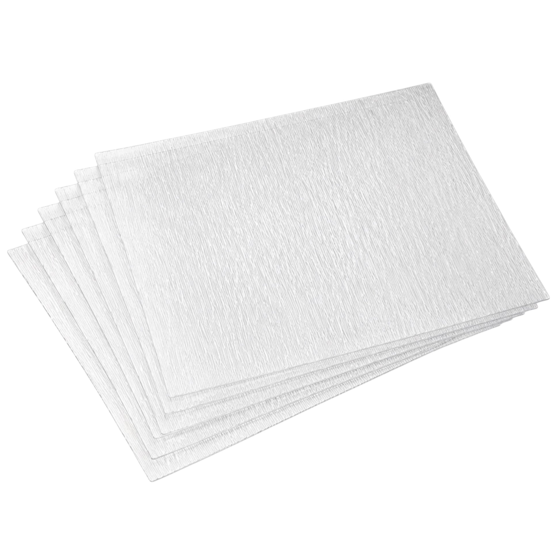 A stack of six textured white rectangular placemats with a subtle embossed pattern, arranged diagonally on a solid white background.